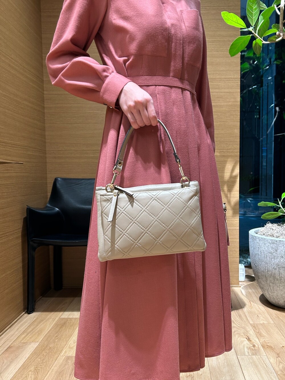 ピンク系のワンピース、ベージュ系のバックパック/リュックを着用したレディースの秋コーディネートの4枚目の写真