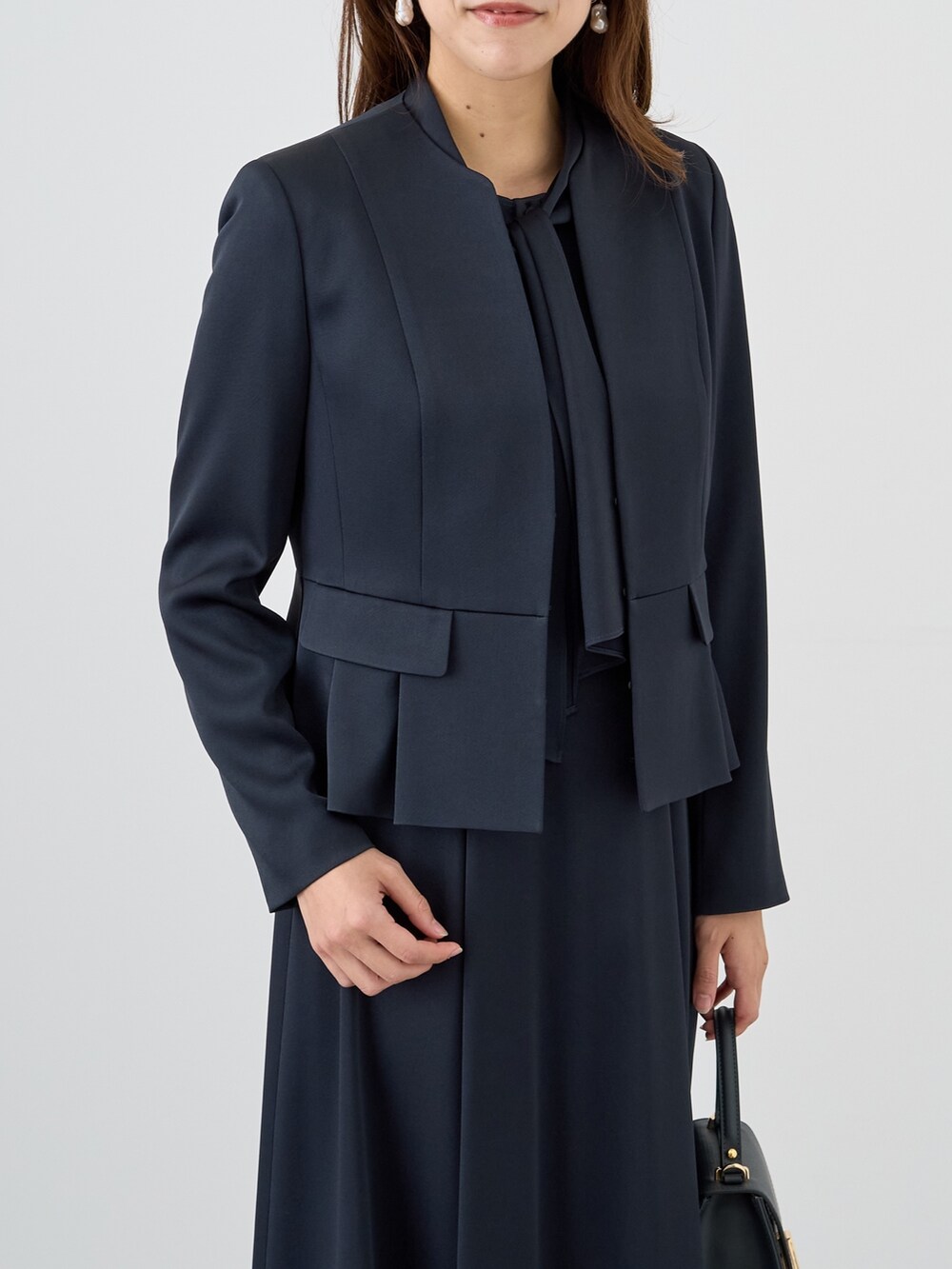 ブルー系のノーカラージャケット、ブルー系のワンピース、ブルー系のトートバッグを着用したレディースの秋コーディネートの4枚目の写真