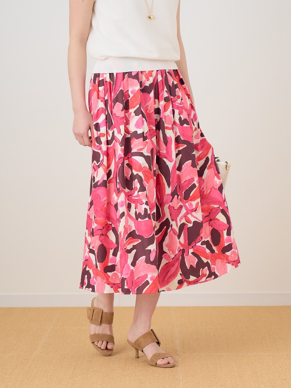 ピンク系のスカート、ホワイト系のニット/セーターを着用したレディースの春コーディネートの3枚目の写真