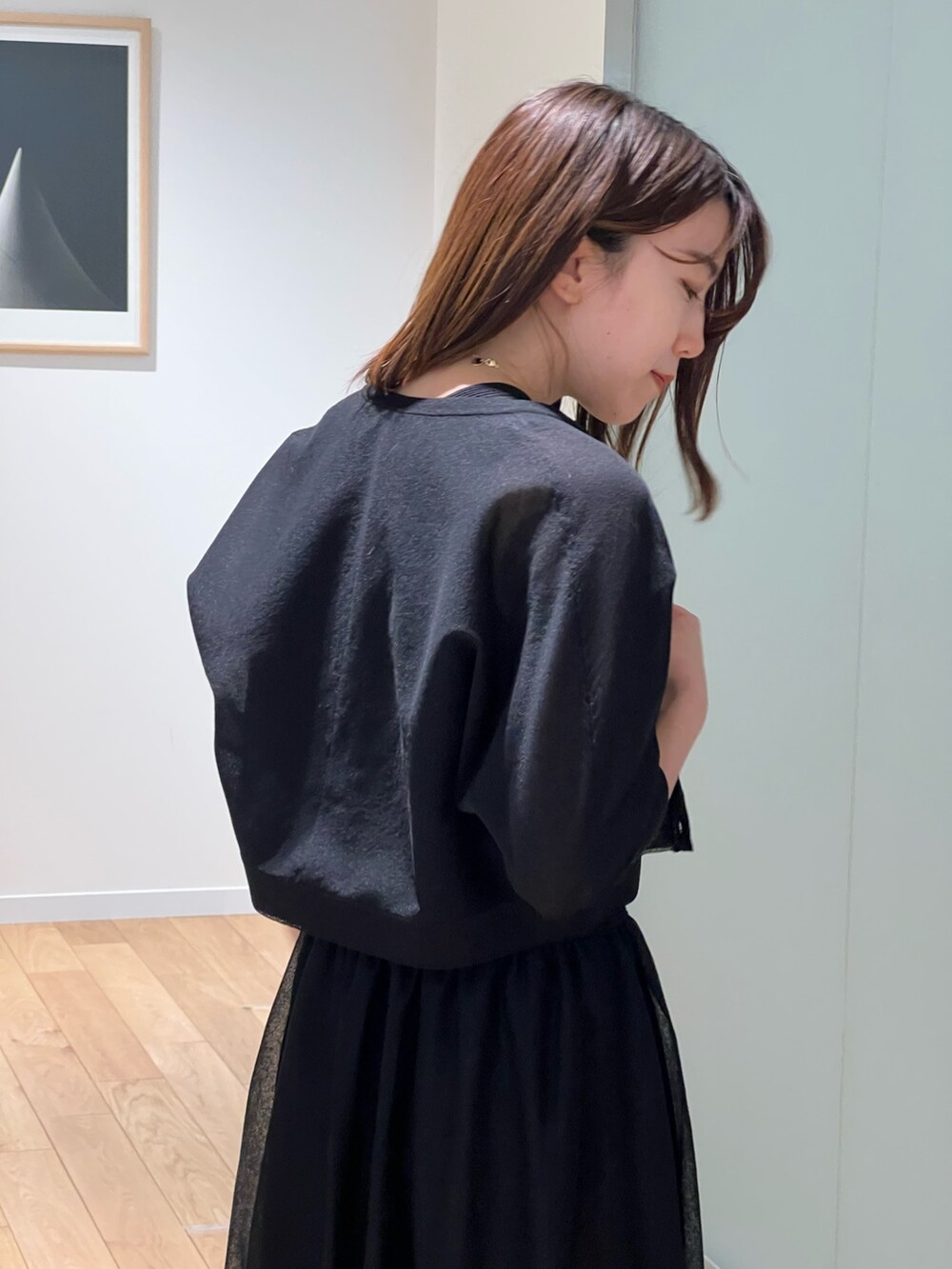 ブラック系のワンピース、ブラック系のカーディガン/ボレロ、シルバー系のネックレスを着用したレディースの春コーディネートの3枚目の写真