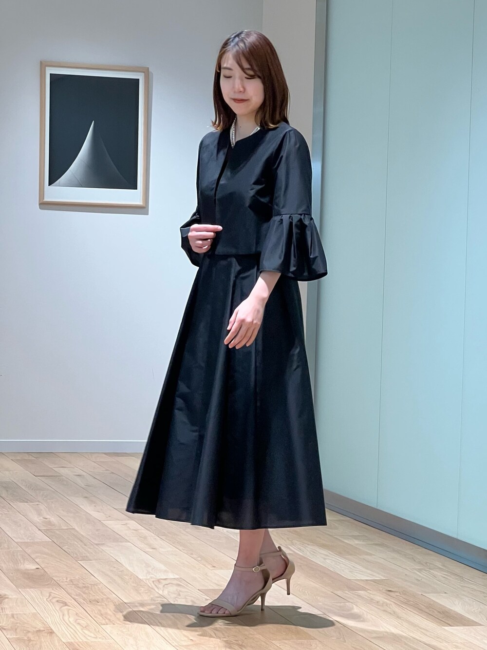 ブラック系のノーカラージャケット、ブラック系のワンピース、ホワイト系のネックレスを着用したレディースの春コーディネートの3枚目の写真