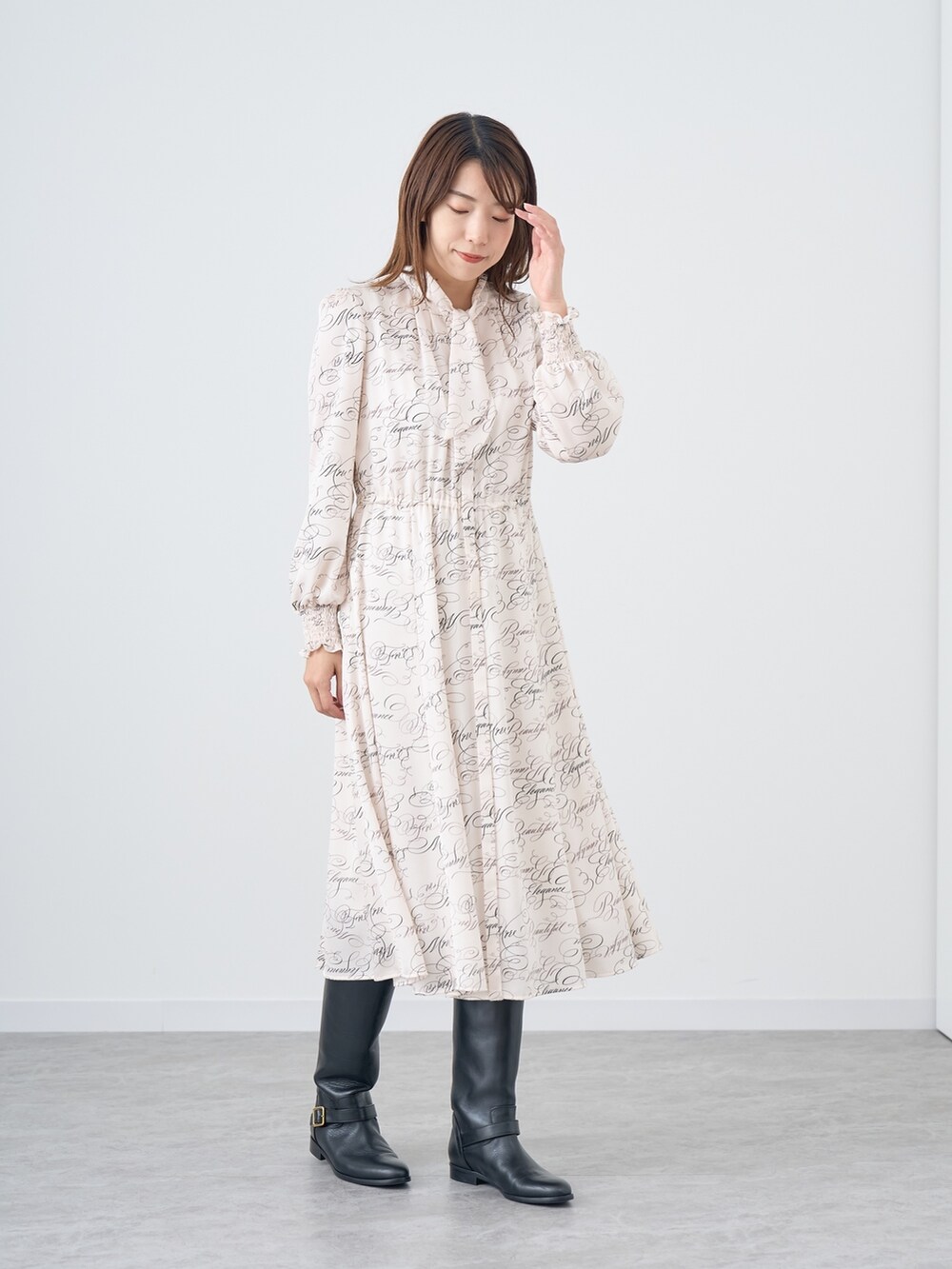 イエロー系のテーラードジャケット、ホワイト系のワンピースを着用したレディースの秋コーディネートの2枚目の写真