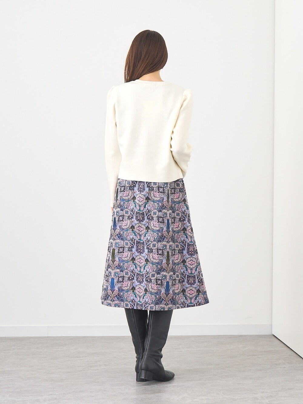 ホワイト系のカーディガン/ボレロ、ブルー系のワンピース、シルバー系のイヤリングを着用したレディースの秋コーディネートの2枚目の写真