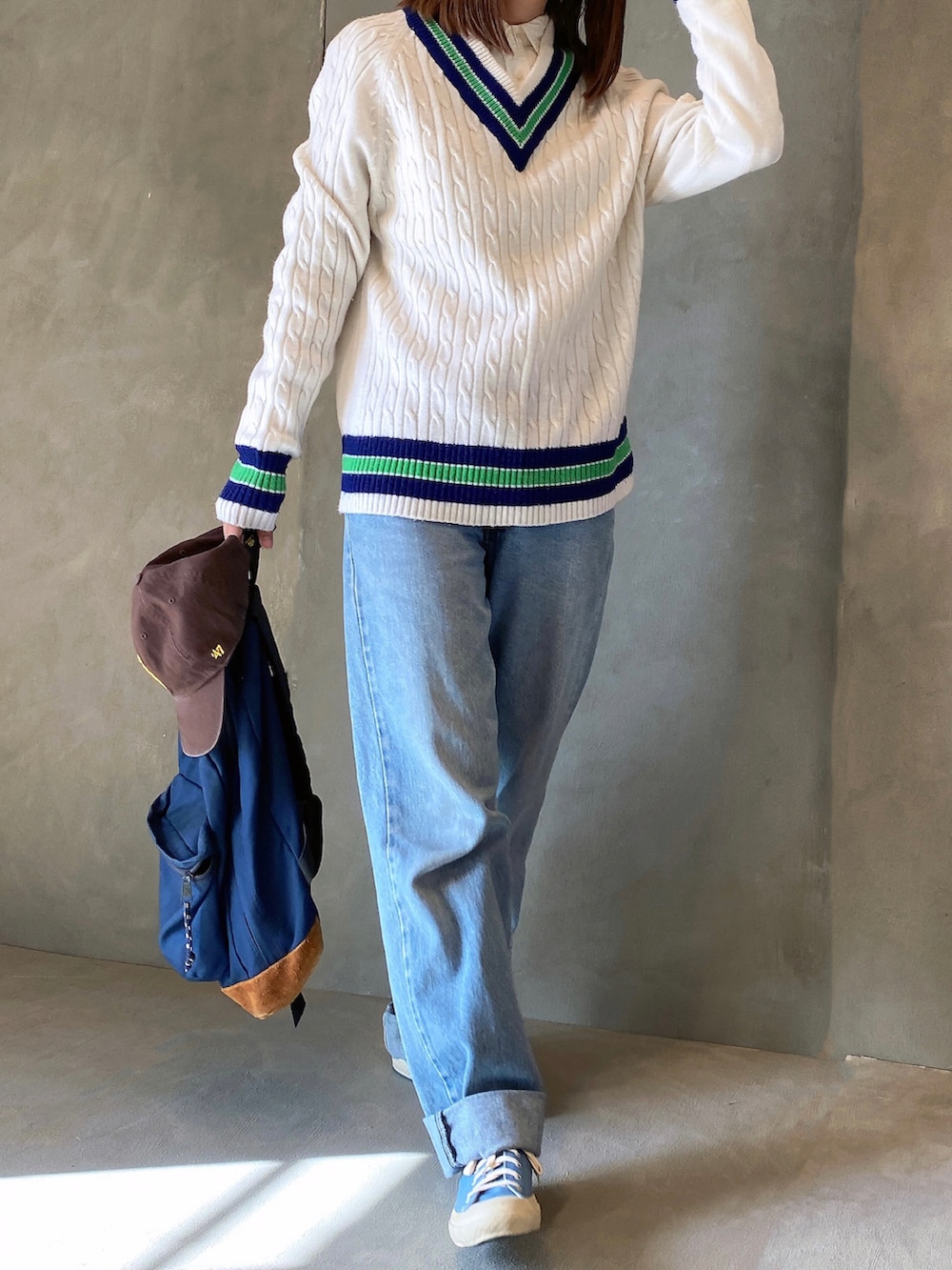 ブルー系のデニムパンツ、ブルー系のスニーカー、ホワイト系のニット/セーターを着用したレディースの冬コーディネートの4枚目の写真