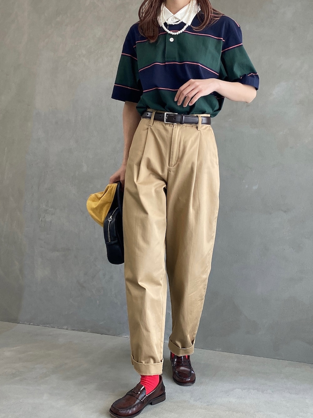 ブラウン系のその他パンツ、グリーン系のポロシャツ、イエロー系のキャップを着用したレディースの春コーディネートの2枚目の写真