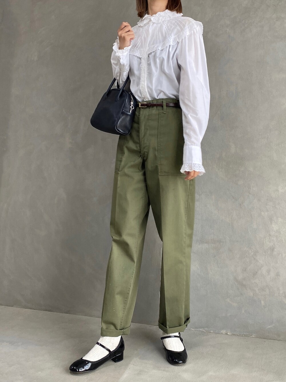 ホワイト系のシャツ/ブラウス、グリーン系のパンツ、ブラック系のボストンバッグを着用したレディースの秋コーディネートの3枚目の写真