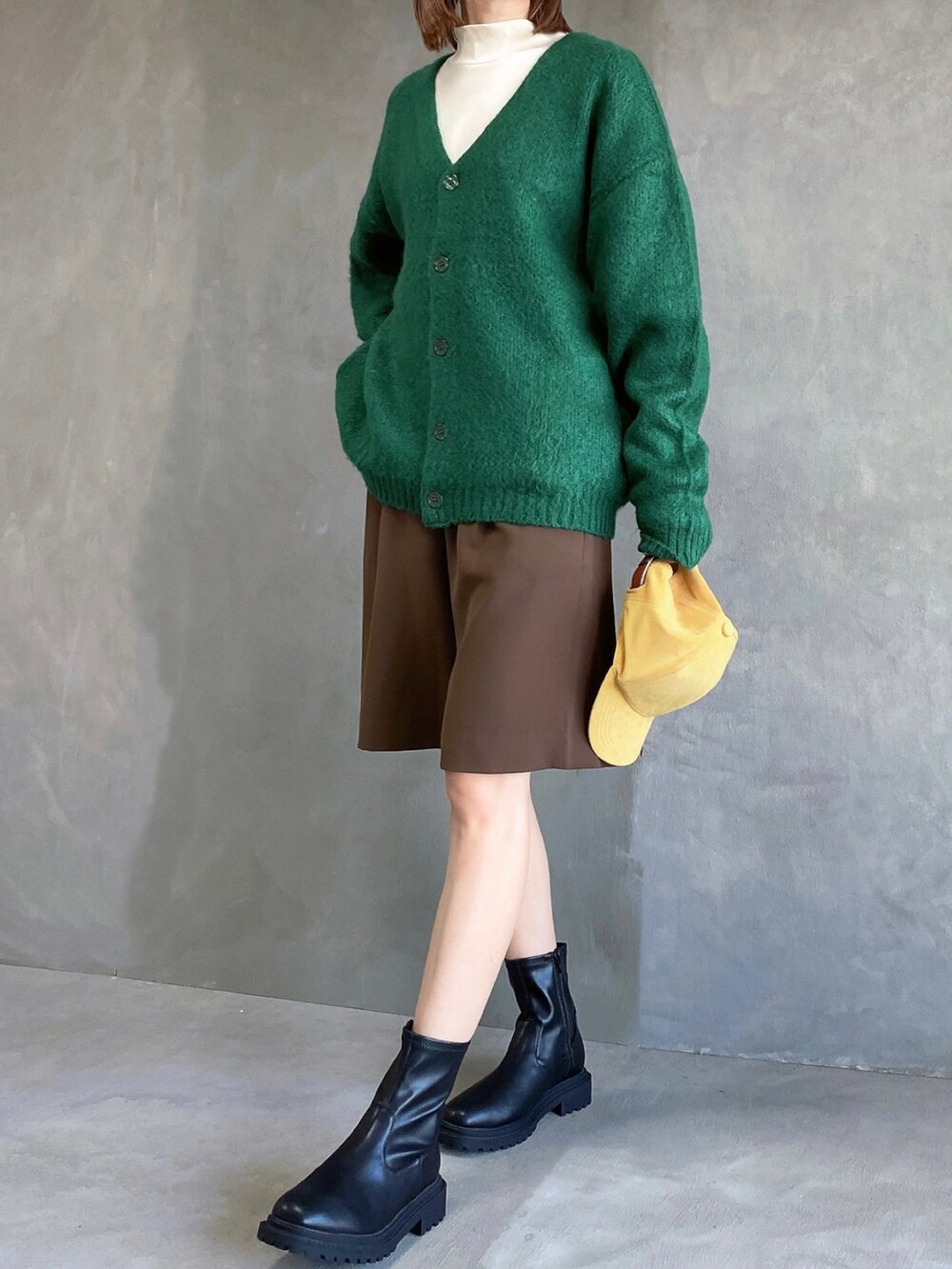 グリーン系のカーディガン/ボレロ、ブラウン系のその他パンツ、ブラック系のブーツを着用したレディースの秋コーディネートの3枚目の写真