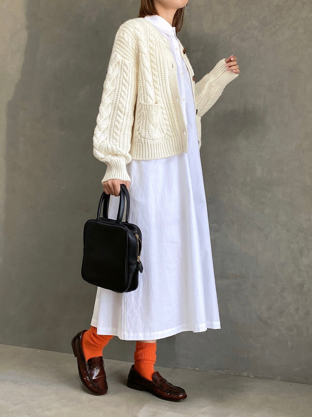ホワイト系のワンピース/ドレス、ブラック系のハンドバッグ、ホワイト系のカーディガン/ボレロを着用したレディースの秋コーディネートの3枚目の写真
