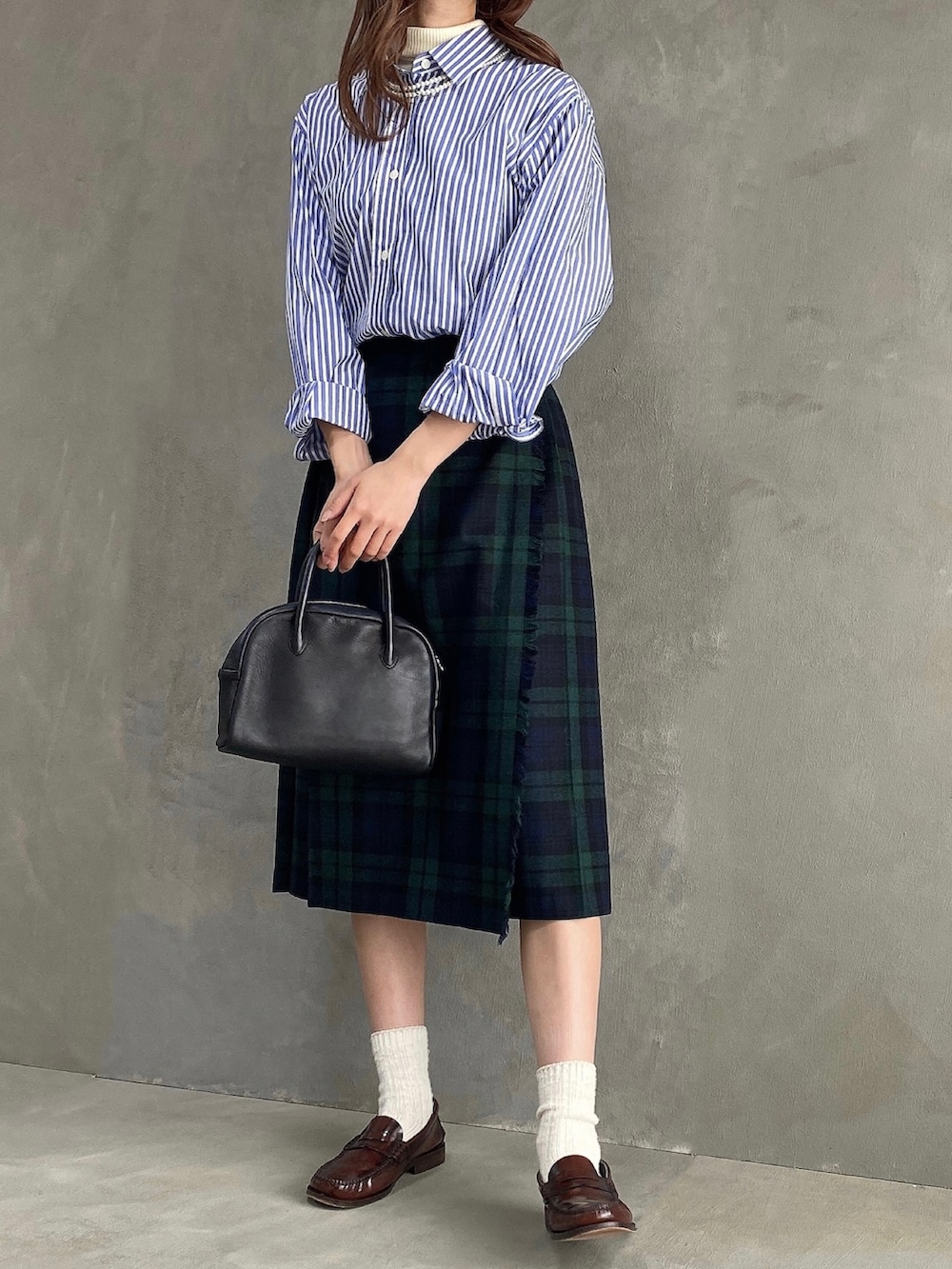 ブラック系のスカート、ブルー系のシャツ/ブラウス、ブラック系のボストンバッグを着用したレディースの春コーディネートの2枚目の写真
