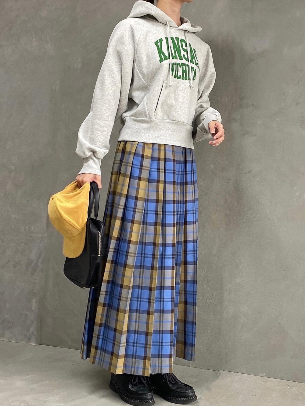 ブルー系のスカート、グレー系のパーカー、ブラック系のドレスシューズを着用したレディースの春コーディネートの3枚目の写真