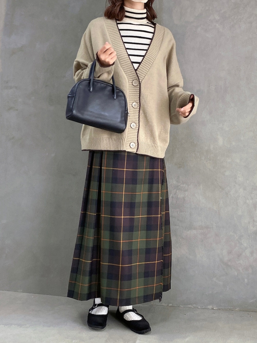 ホワイト系のトップス、ブラウン系のカーディガン/ボレロ、グリーン系のスカートを着用したレディースの冬コーディネートの3枚目の写真