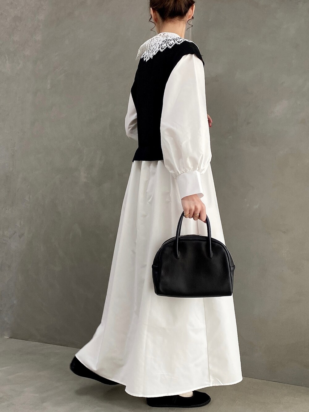 ブラック系のボストンバッグ、ブラック系のワンピース、ブラック系のバレエシューズを着用したレディースの春コーディネートの4枚目の写真