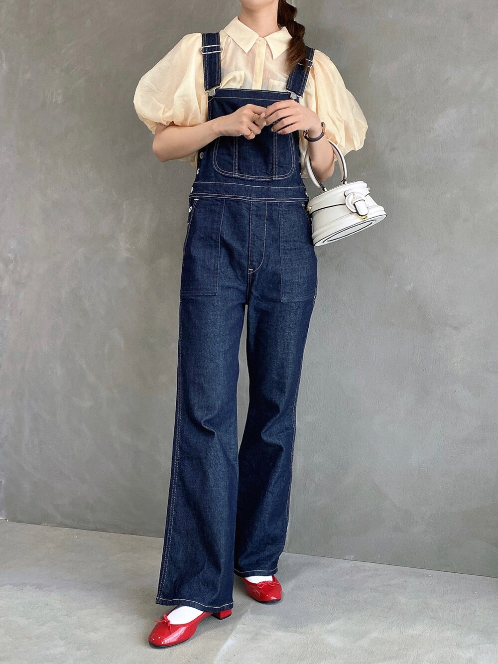 ブルー系のサロペット/オーバーオール、レッド系のパンプス、ベージュ系のシャツ/ブラウスを着用したレディースの夏コーディネートの2枚目の写真