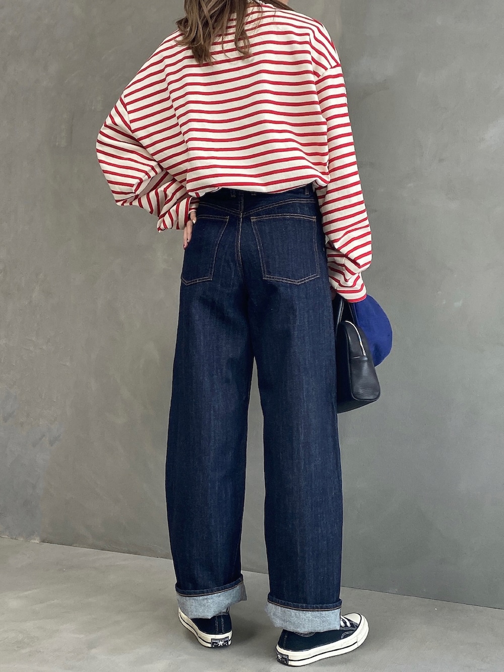 その他のTシャツ/カットソー、ブルー系のデニムパンツ、ブラック系のボストンバッグを着用したレディースの春コーディネートの2枚目の写真