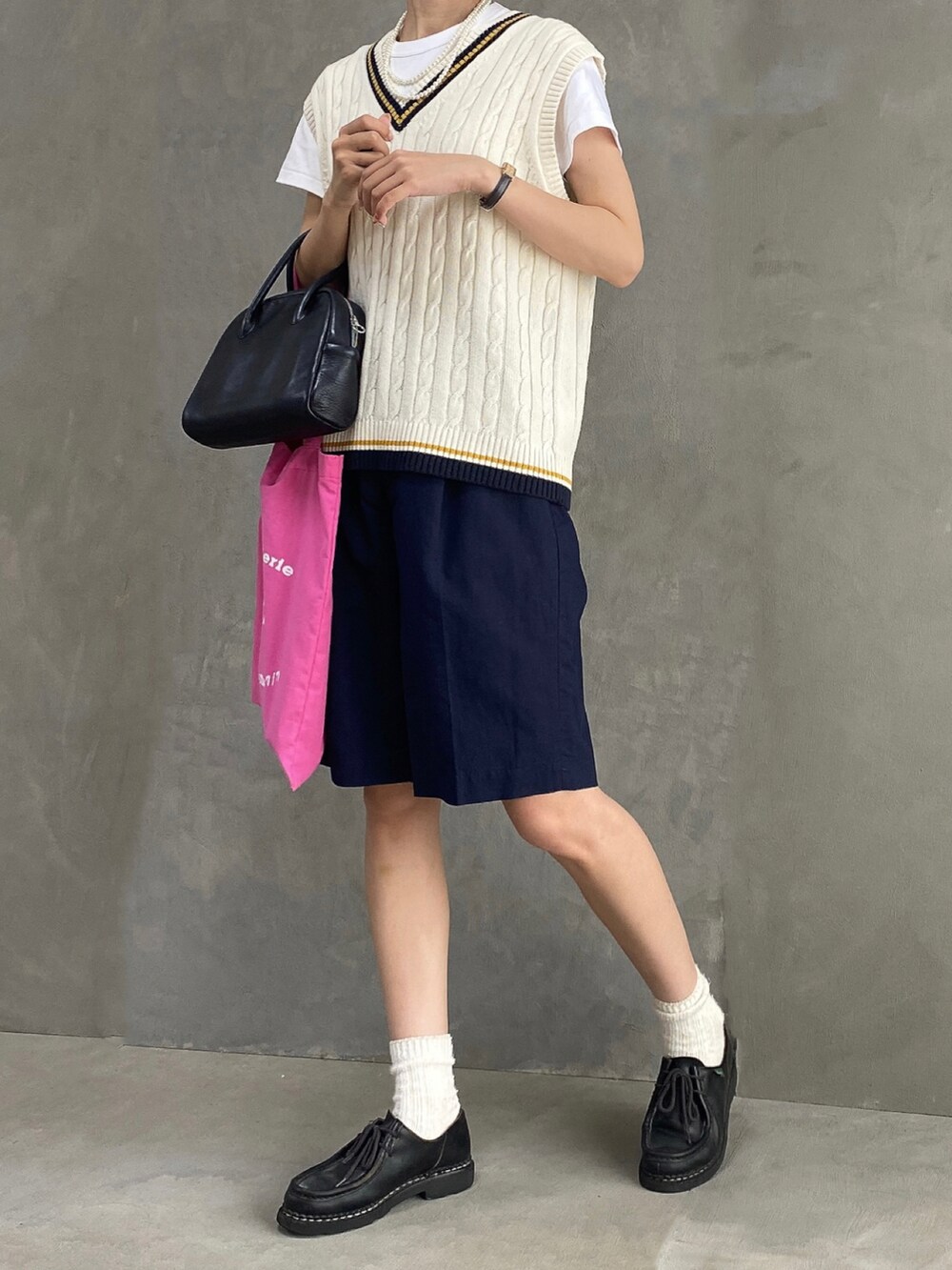 ブラック系のパンツ、ピンク系のバッグ、ブラック系のドレスシューズを着用したレディースの夏コーディネートの3枚目の写真