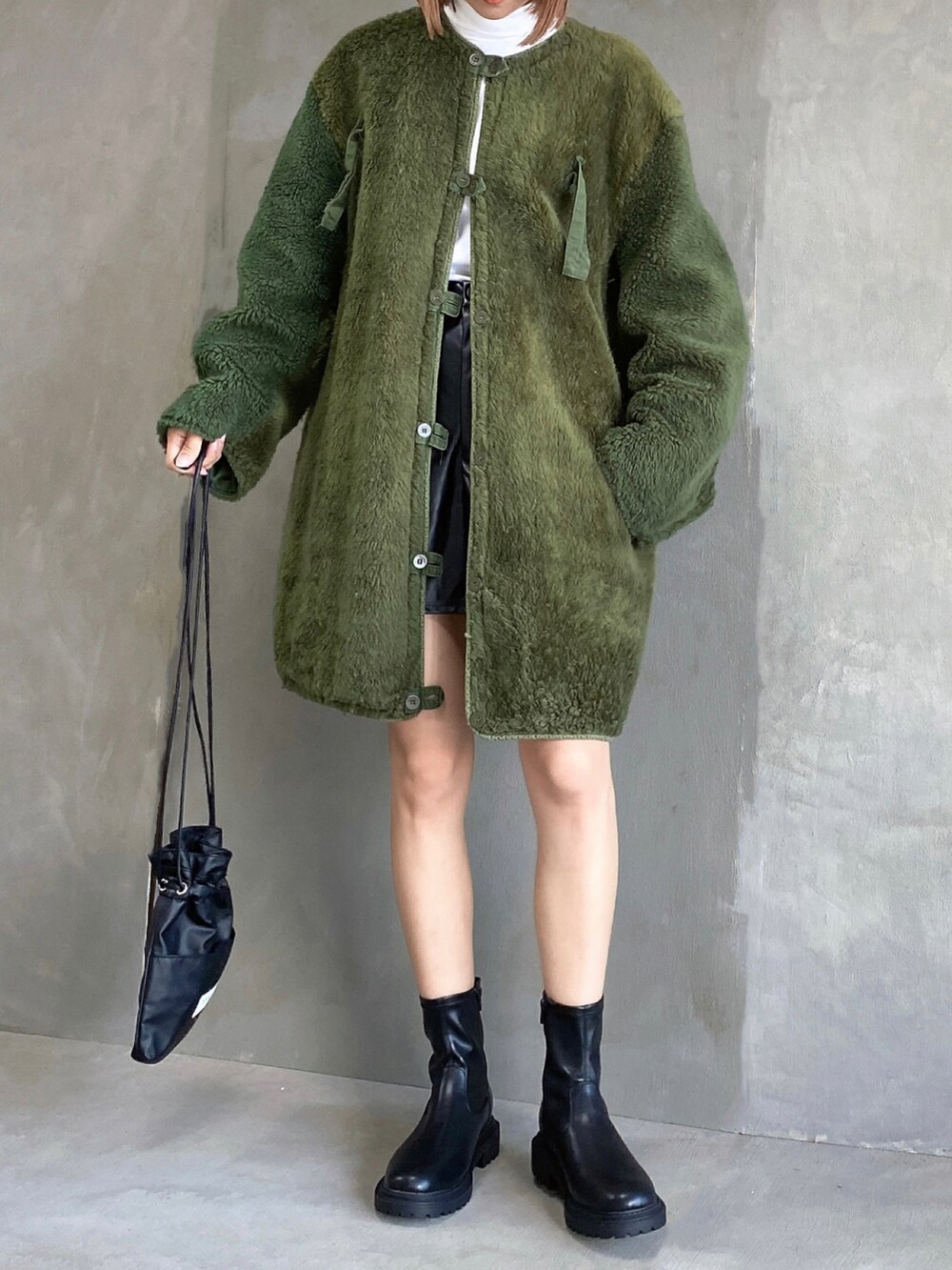 ホワイト系のトップス、ブラック系のパンツ、グリーン系のジャケット/アウターを着用したレディースの秋コーディネートの2枚目の写真