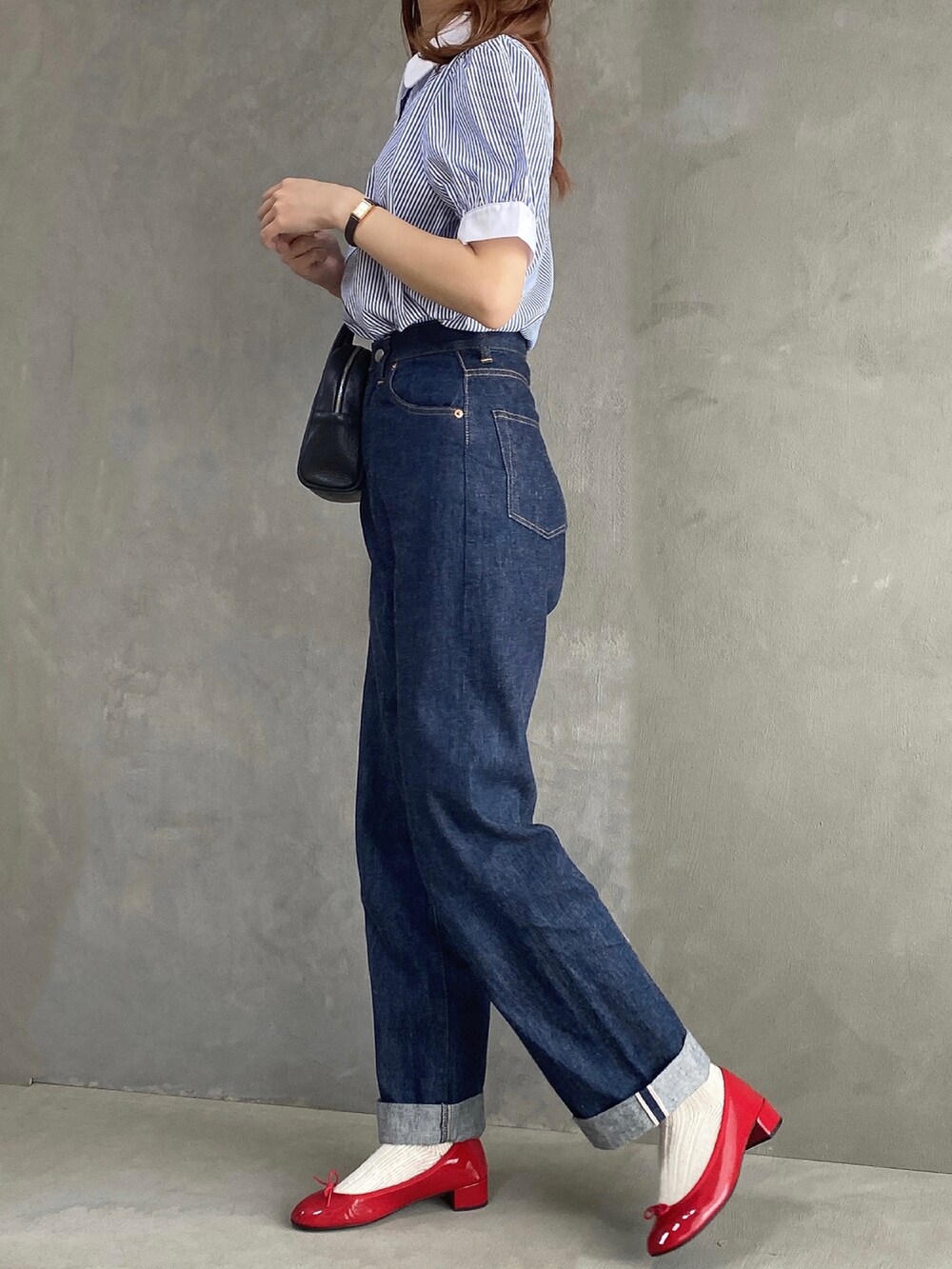 ブルー系のシャツ/ブラウス、ブラック系のボストンバッグ、ブルー系のデニムパンツを着用したレディースの春コーディネートの3枚目の写真