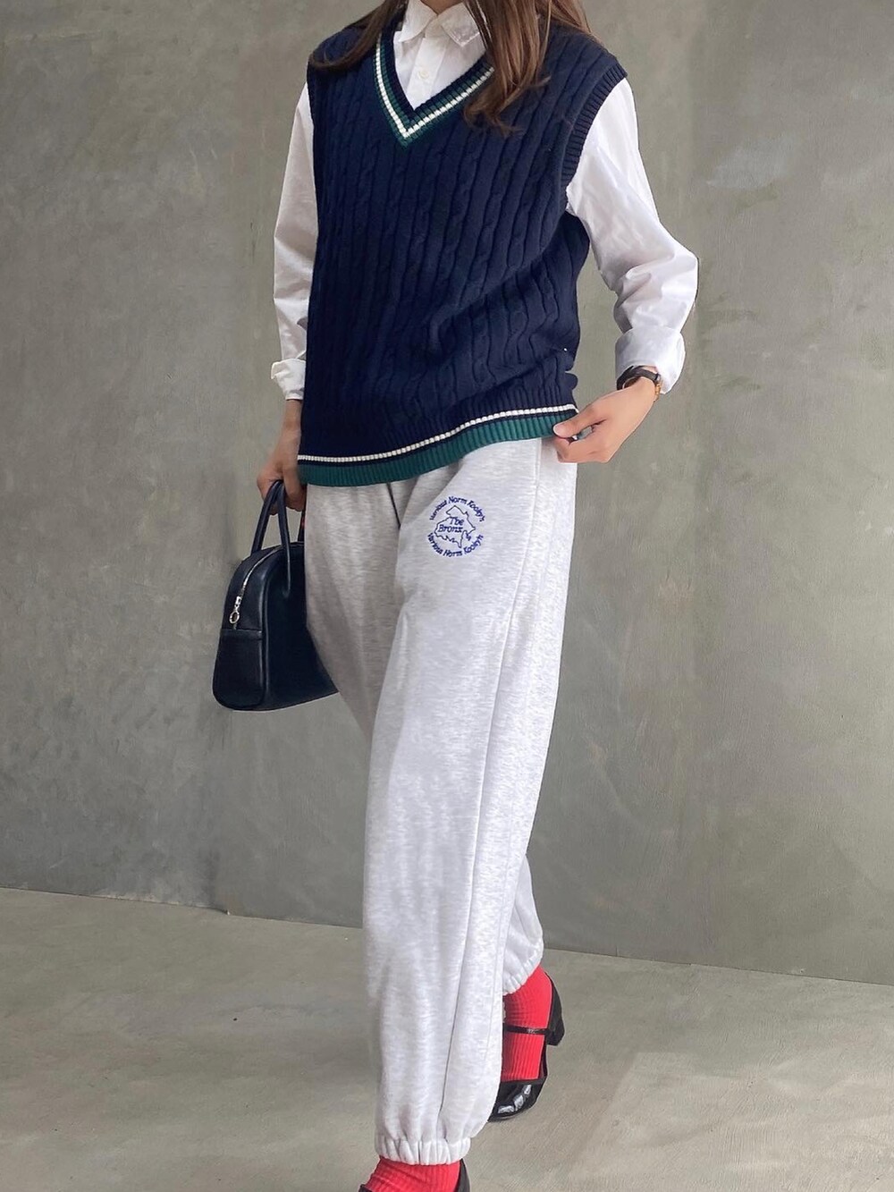 ブラック系のベスト、ブラック系のボストンバッグ、グレー系のスウェットパンツを着用したレディースの秋コーディネートの2枚目の写真