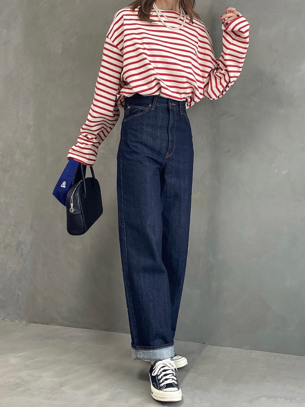 その他のTシャツ/カットソー、ブルー系のデニムパンツ、ブラック系のボストンバッグを着用したレディースの春コーディネートの3枚目の写真