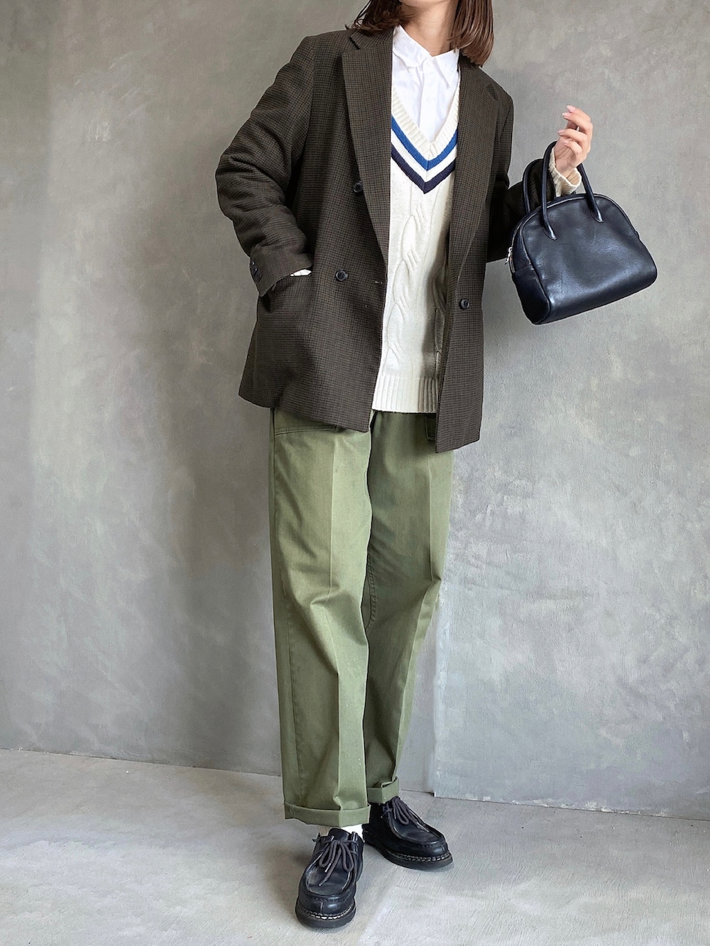 ブラウン系のテーラードジャケット、ホワイト系のニット/セーター、グリーン系のパンツを着用したレディースの冬コーディネートの2枚目の写真