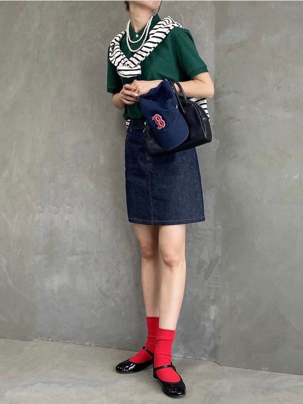 ブルー系のスカート、ブラック系のパンプス、グリーン系のポロシャツを着用したレディースの夏コーディネートの2枚目の写真