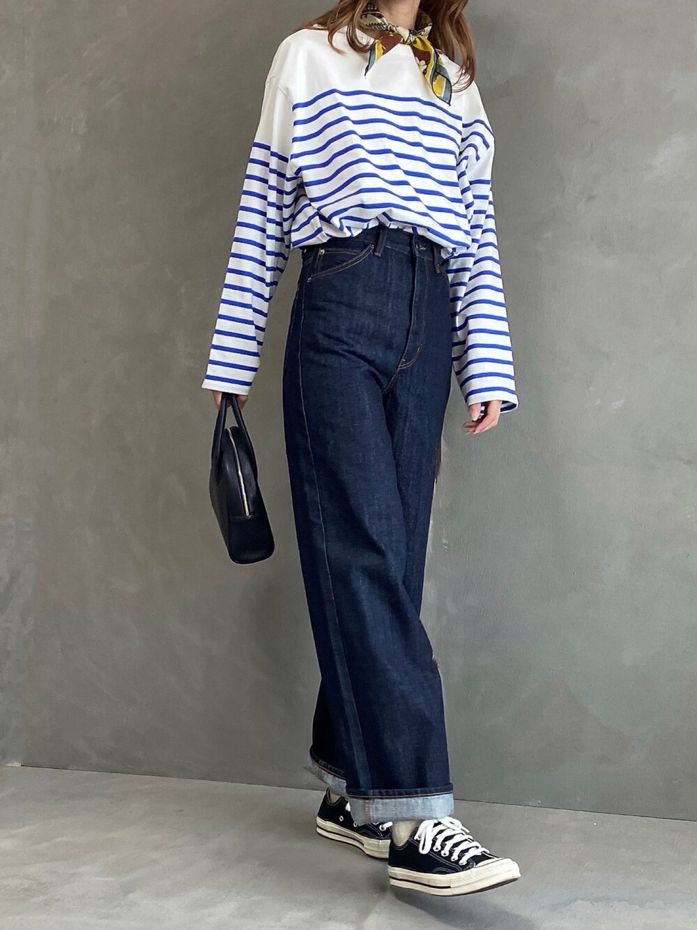 ブルー系のTシャツ/カットソー、ブルー系のデニムパンツ、ブラック系のボストンバッグを着用したレディースの春コーディネートの2枚目の写真