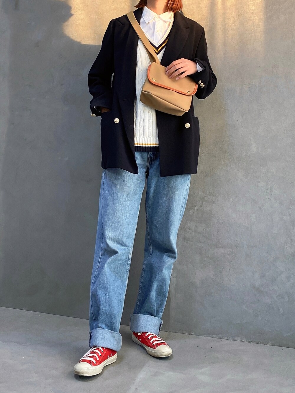 ブルー系のテーラードジャケット、ホワイト系のニット/セーター、ブルー系のデニムパンツを着用したレディースの秋コーディネートの3枚目の写真