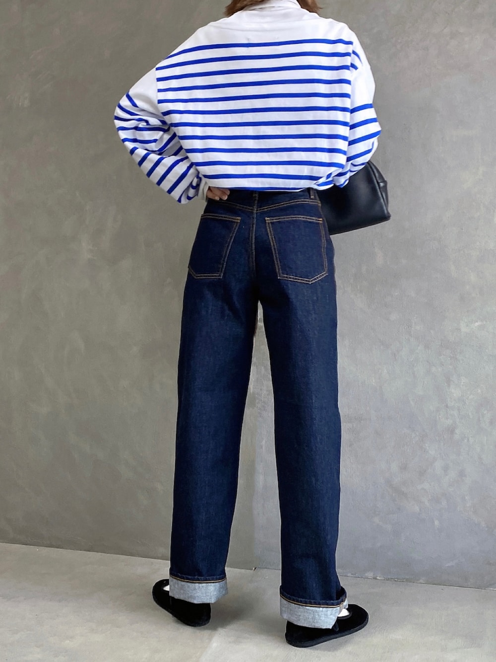 ホワイト系のTシャツ/カットソー、ブルー系のデニムパンツ、ブラック系のボストンバッグを着用したレディースの秋コーディネートの2枚目の写真