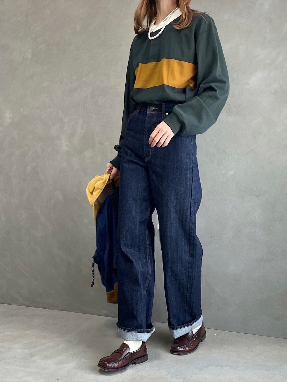 ブルー系のバックパック/リュック、グリーン系のTシャツ/カットソー、ブルー系のデニムパンツを着用したレディースの春コーディネートの3枚目の写真