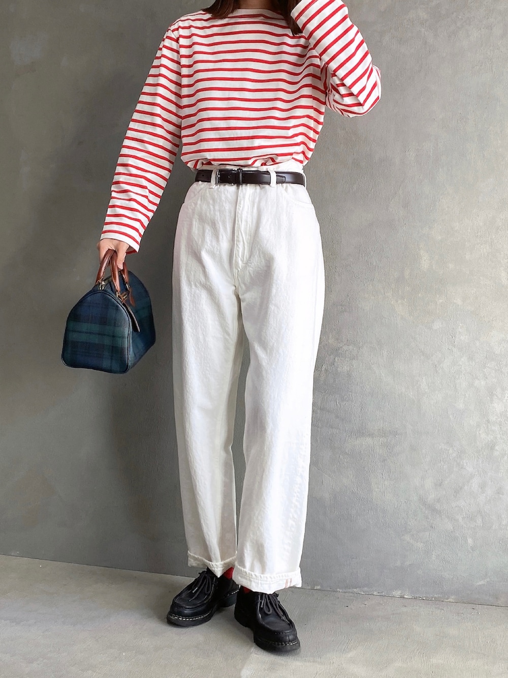 ブラウン系のジャケット/アウター、レッド系のTシャツ/カットソー、グリーン系のボストンバッグを着用したレディースの冬コーディネートの2枚目の写真