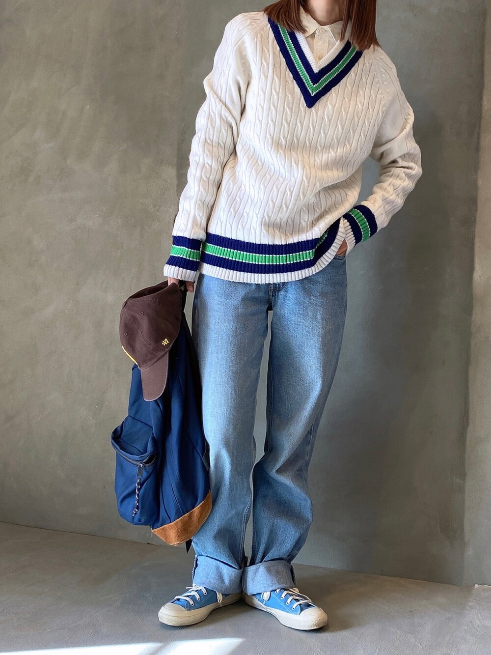 ブルー系のデニムパンツ、ブルー系のスニーカー、ホワイト系のニット/セーターを着用したレディースの冬コーディネートの2枚目の写真