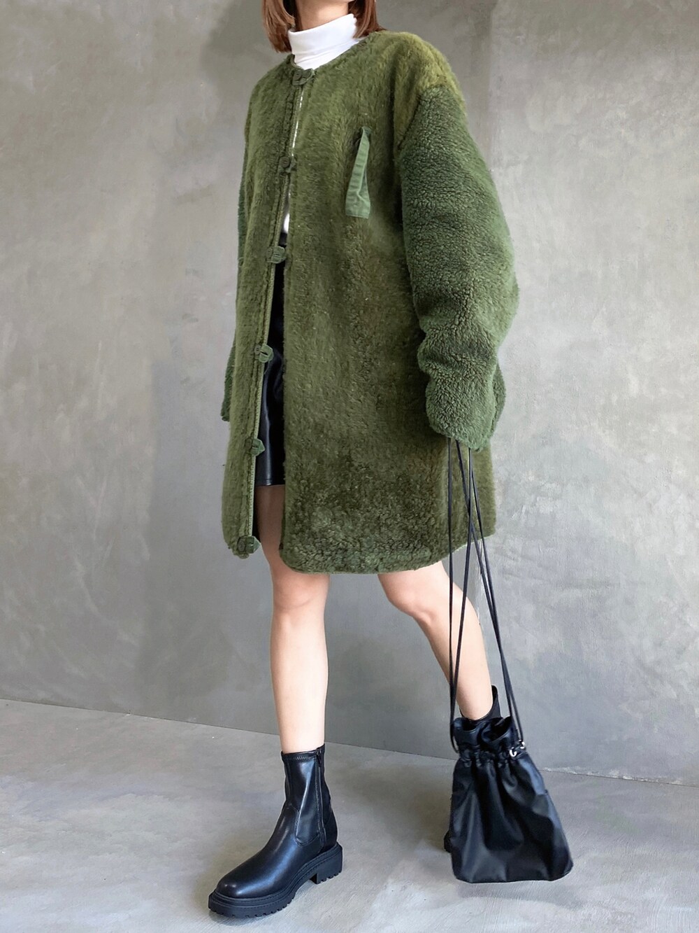 ホワイト系のトップス、ブラック系のパンツ、グリーン系のジャケット/アウターを着用したレディースの秋コーディネートの3枚目の写真