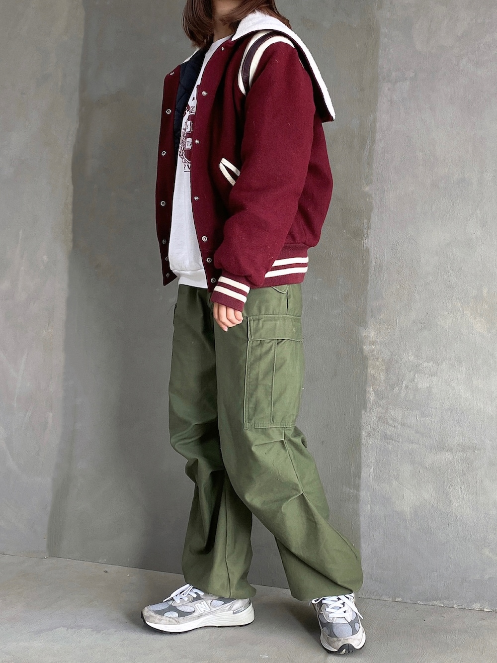グレー系のスニーカー、グリーン系のカーゴパンツ、ホワイト系のスウェットを着用したレディースの冬コーディネートの2枚目の写真
