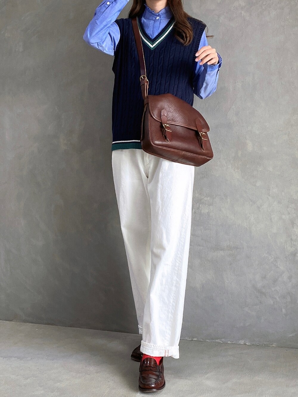 ホワイト系のデニムパンツ、ブルー系のシャツ/ブラウス、ブラック系のベストを着用したレディースの秋コーディネートの3枚目の写真