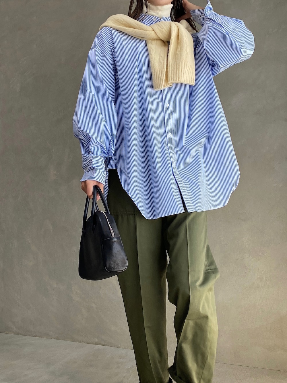 ブラック系のボストンバッグ、ブルー系のシャツ/ブラウス、グリーン系のチノパンツを着用したレディースの春コーディネートの2枚目の写真