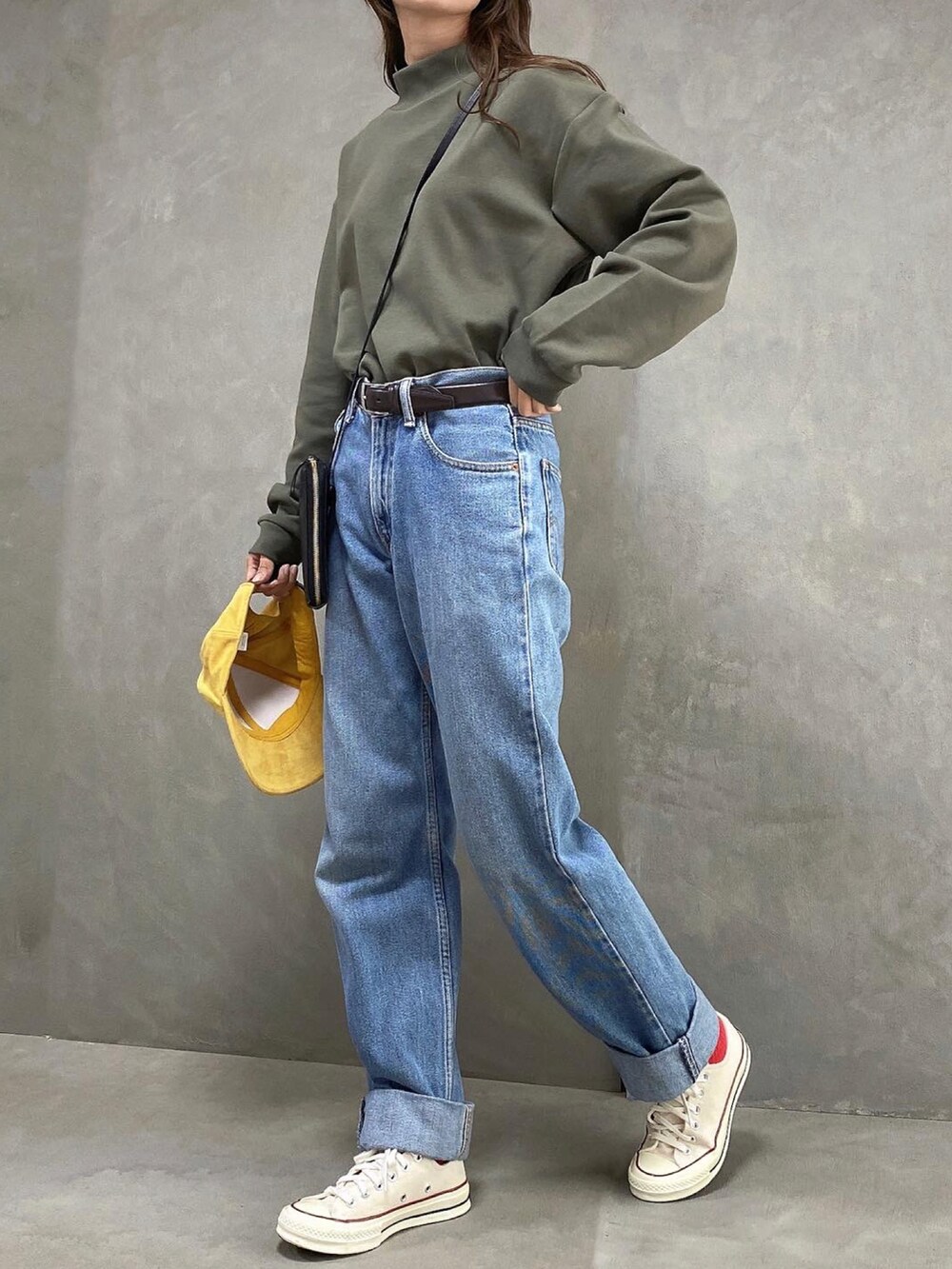 グリーン系のトップス、ブルー系のデニムパンツを着用したレディースの秋コーディネートの2枚目の写真