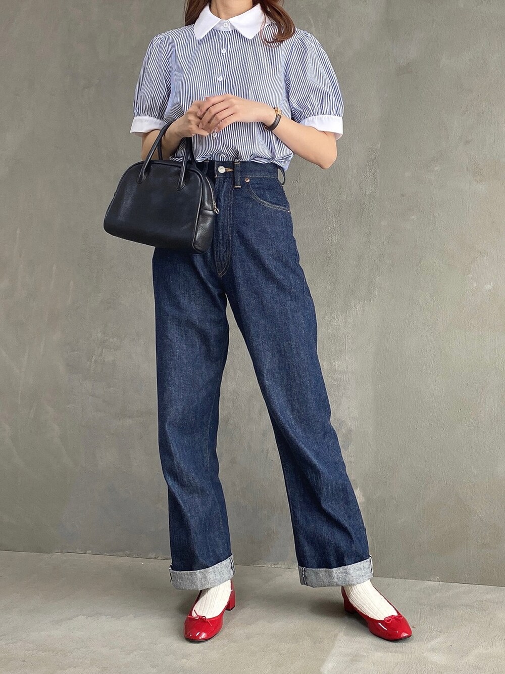 ブルー系のシャツ/ブラウス、ブラック系のボストンバッグ、ブルー系のデニムパンツを着用したレディースの春コーディネートの2枚目の写真