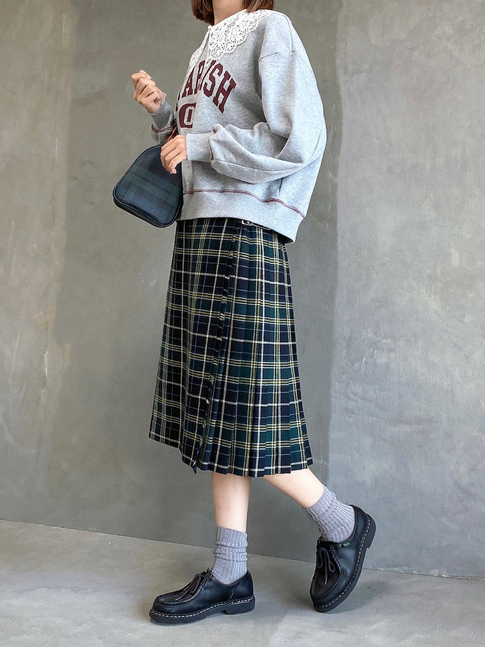 グリーン系のボストンバッグ、グレー系のスウェット、グリーン系のスカートを着用したレディースの秋コーディネートの2枚目の写真