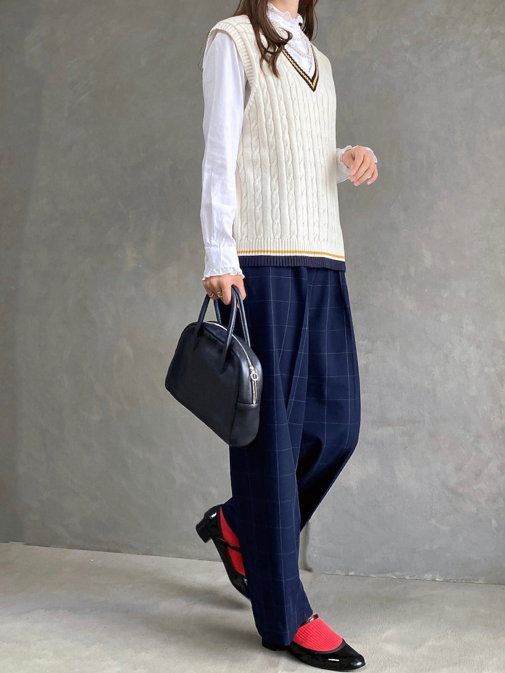 ブルー系のスラックス、ブラック系のボストンバッグ、ブラック系のパンプスを着用したレディースの秋コーディネートの2枚目の写真