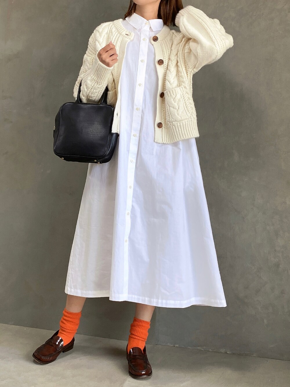 ホワイト系のワンピース/ドレス、ブラック系のハンドバッグ、ホワイト系のカーディガン/ボレロを着用したレディースの秋コーディネートの2枚目の写真