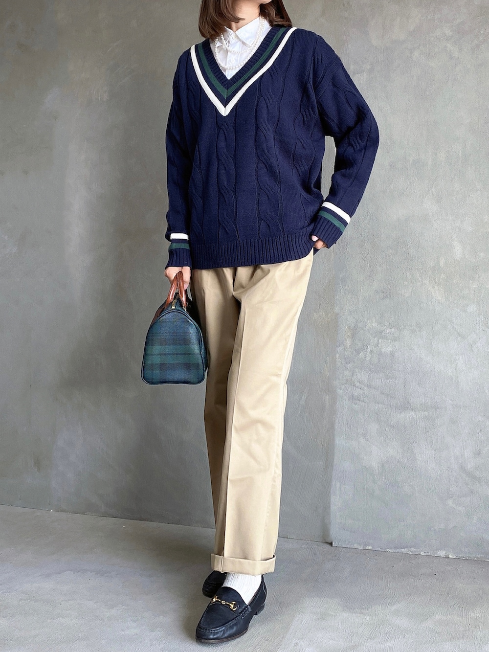 ブラック系のジャケット/アウター、その他のニット/セーター、ベージュ系のチノパンツを着用したレディースの冬コーディネートの2枚目の写真