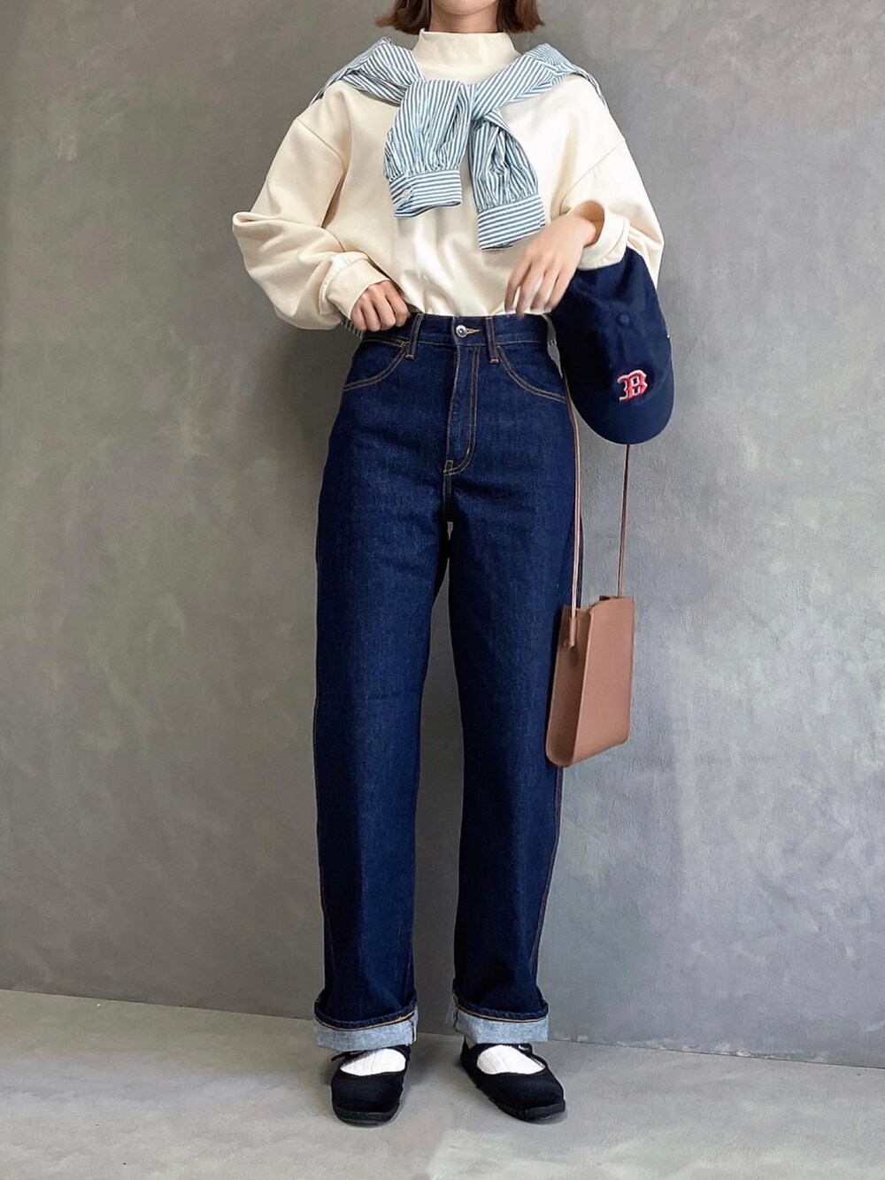 ホワイト系のトップス、ブルー系のデニムパンツ、ブラック系のバレエシューズを着用したレディースの秋コーディネートの2枚目の写真