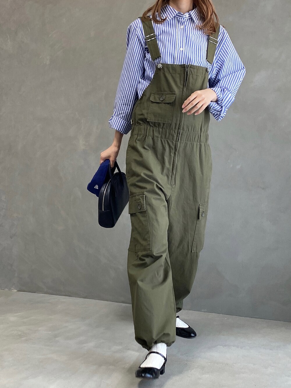 ブラック系のボストンバッグ、ブラック系のパンプス、ブルー系のシャツ/ブラウスを着用したレディースの春コーディネートの2枚目の写真