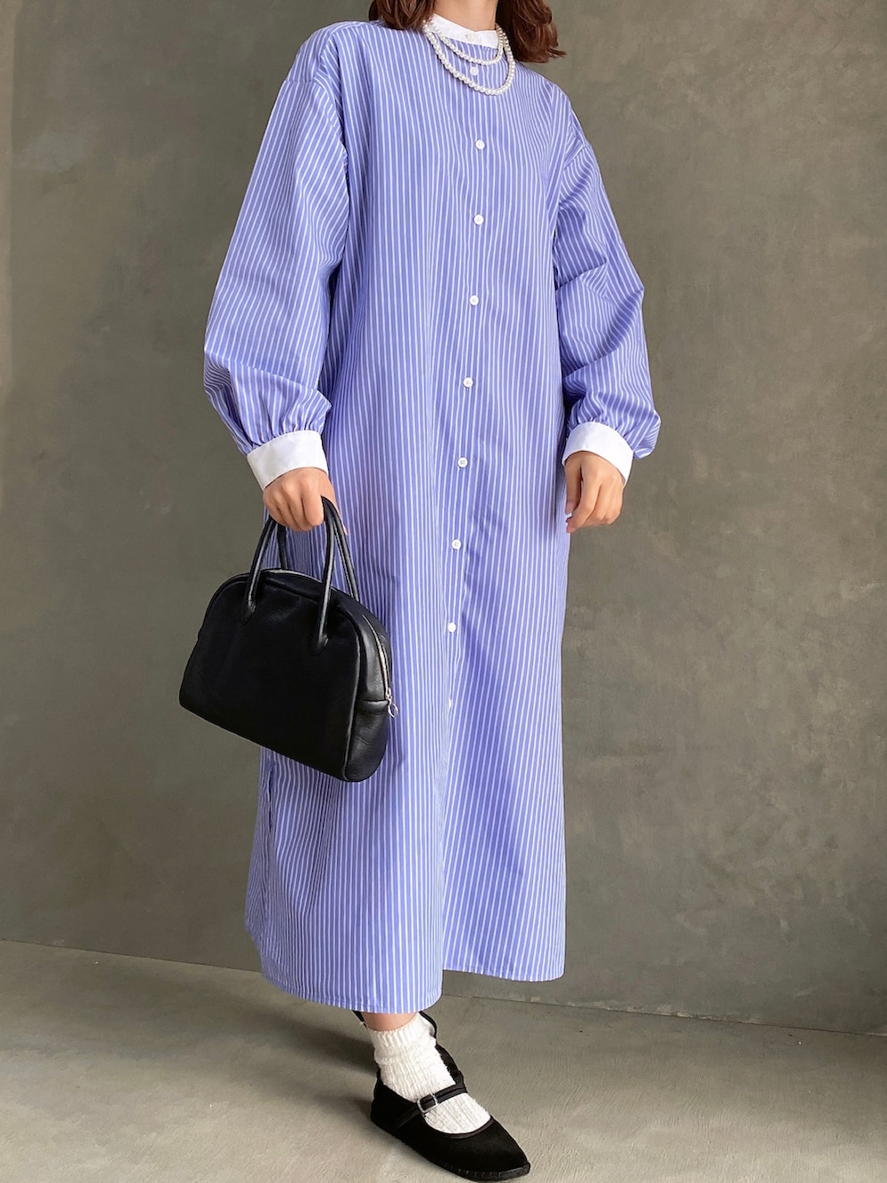 ブルー系のワンピース/ドレス、ホワイト系のニット/セーター、ブラック系のボストンバッグを着用したレディースの冬コーディネートの2枚目の写真