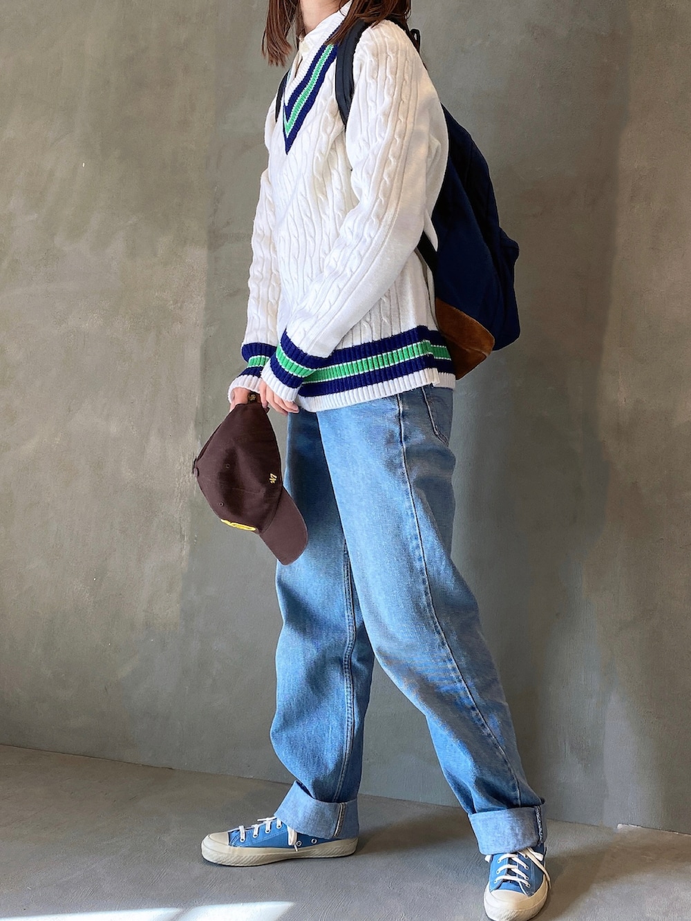 ブルー系のデニムパンツ、ブルー系のスニーカー、ホワイト系のニット/セーターを着用したレディースの冬コーディネートの3枚目の写真