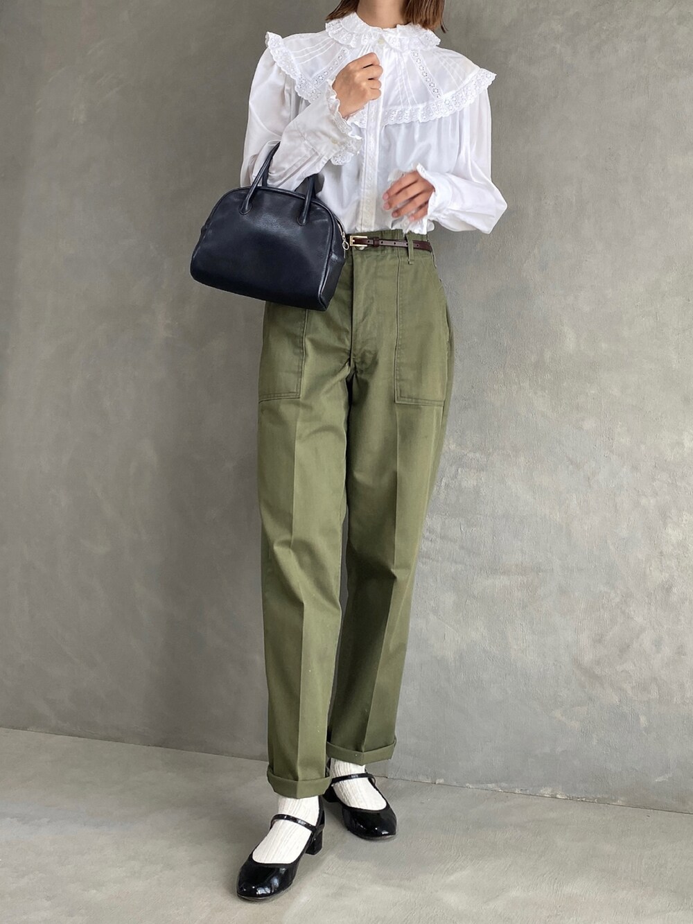 ホワイト系のシャツ/ブラウス、グリーン系のパンツ、ブラック系のボストンバッグを着用したレディースの秋コーディネートの2枚目の写真