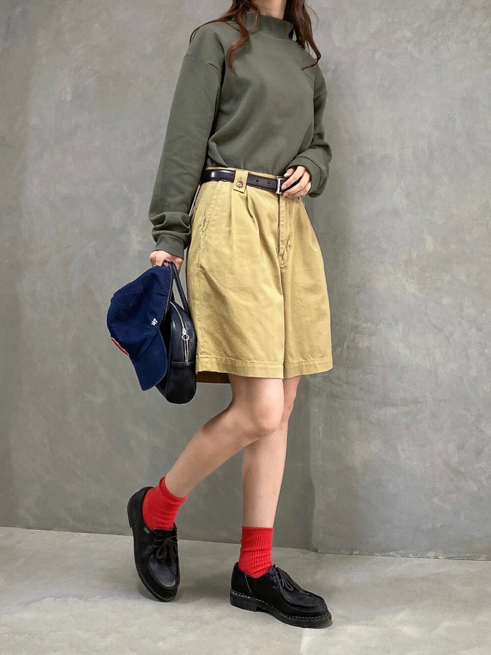 ブラック系のドレスシューズ、ベージュ系のパンツ、グリーン系のトップスを着用したレディースの秋コーディネートの2枚目の写真