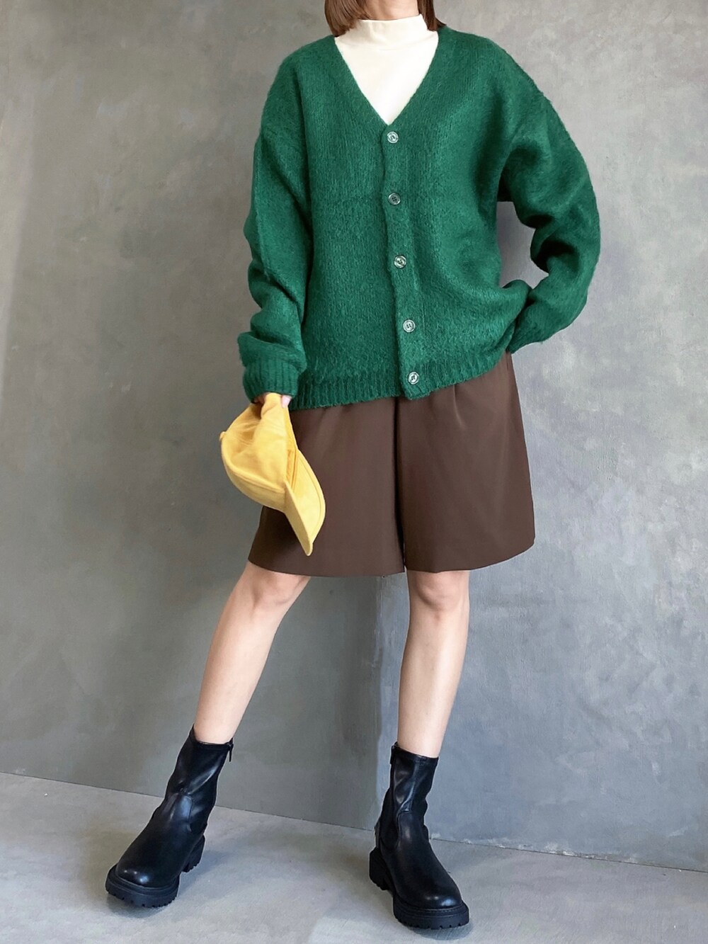 グリーン系のカーディガン/ボレロ、ブラウン系のその他パンツ、ブラック系のブーツを着用したレディースの秋コーディネートの2枚目の写真