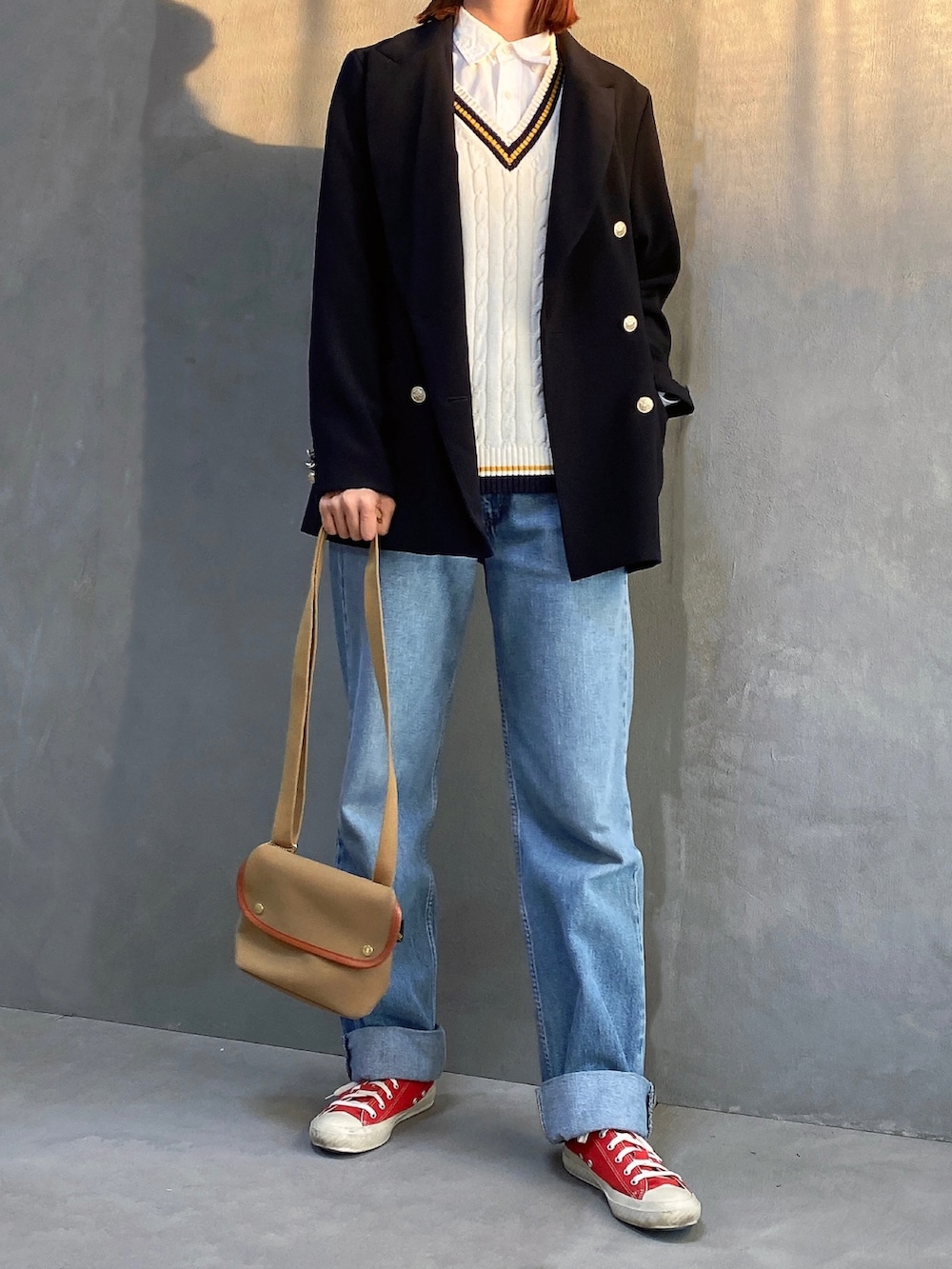 ブルー系のテーラードジャケット、ホワイト系のニット/セーター、ブルー系のデニムパンツを着用したレディースの秋コーディネートの2枚目の写真
