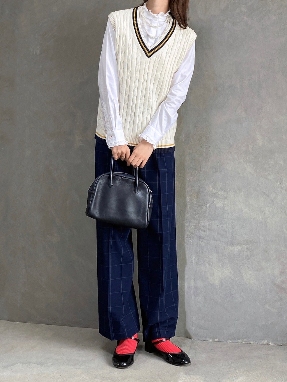 ブルー系のスラックス、ブラック系のボストンバッグ、ブラック系のパンプスを着用したレディースの秋コーディネートの3枚目の写真